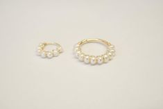 two gold rings with pearls on them