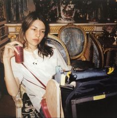 a woman sitting in a chair holding a drink