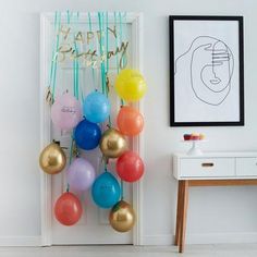 balloons are hanging on the wall near a table