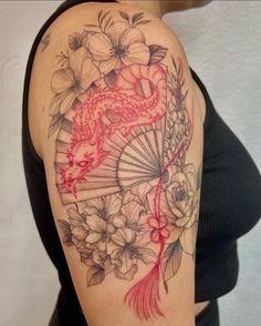 a woman with a tattoo on her arm has a fish and flowers in the background