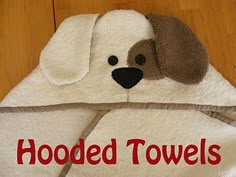 a white towel with a brown dog's face on it sitting on a wooden floor