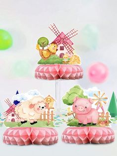 three tiered cake with farm animals and windmills on top, in front of balloons