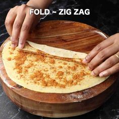 a person is making food on a wooden platter with the words fold - zig zag