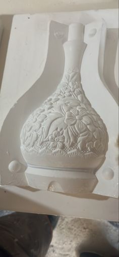 a white vase sitting on top of a shelf