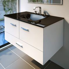 a bathroom with a black counter top and white cabinetry next to a glass door