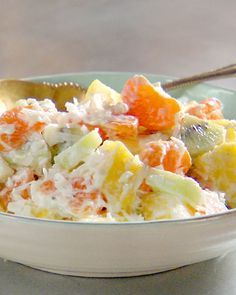 a bowl filled with fruit salad on top of a table