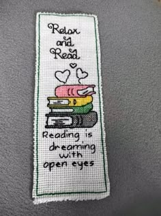 a cross stitch bookmark with the words relax and read reading is dreaming with open eyes