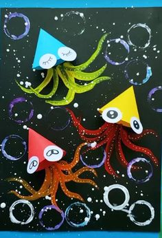 an art project with paper and scissors on top of a piece of artwork that looks like octopus