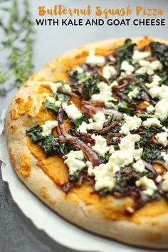 a close up of a pizza on a plate with cheese and spinach toppings