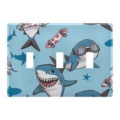 a light switch cover with shark and sharks on it, both have goggles in their mouths