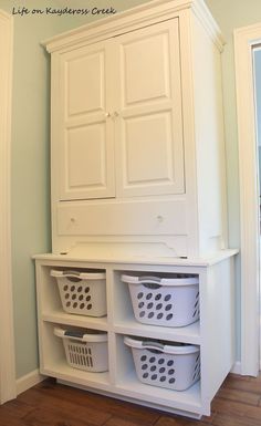 a white cabinet with three baskets on it