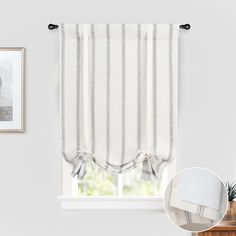 an image of a window with white and grey striped curtains in front of the window