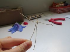 a person is holding a piece of wire with flowers on it