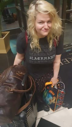 a woman standing next to a brown bag