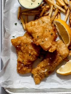 fried fish and fries with dipping sauce on the side