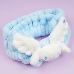 a blue and white stuffed animal on a purple background