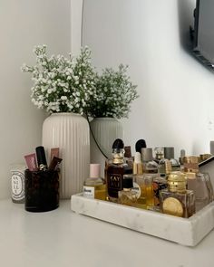 a white vase filled with lots of different types of cosmetics on top of a counter