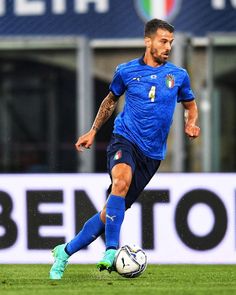 a man kicking a soccer ball on top of a field