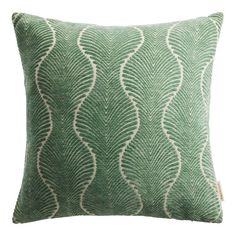 a green and white pillow with an intricate design on the front, featuring wavy leaves