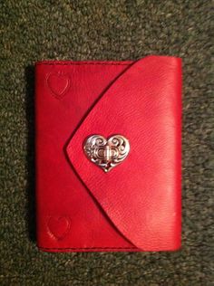 a red leather wallet with a heart on the front and two hearts in the middle