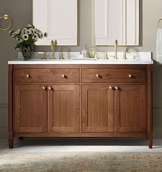 a bathroom vanity with two mirrors above it and a rug on the floor next to it