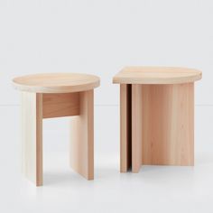 two wooden stools sitting side by side on a white surface with no one around them