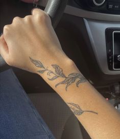 a person with a tattoo on their arm driving a car