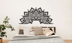 a bedroom with a bed, plant and decorative wall art