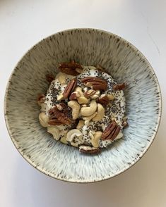 a bowl filled with nuts and yogurt on top of a white countertop