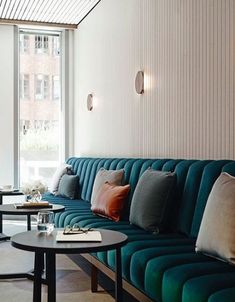 a living room filled with lots of furniture next to a large glass window and a coffee table