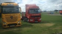 two large trucks parked next to each other on a field