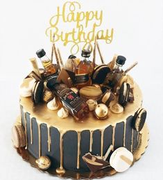 a birthday cake decorated with chocolate and gold icing, including an assortment of confections