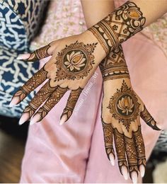 two hands with henna tattoos on them