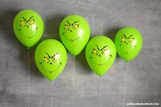 five green balloons with faces drawn on them