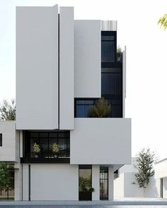 a white building with black balconies on the top and bottom floors is shown