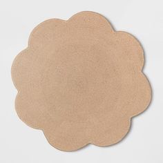 a round placemat with a scalloped edge on a white surface, in the shape of a flower