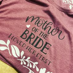 a t - shirt that says mother of the bride and love her first on it