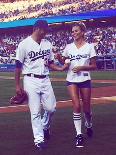 two baseball players walking on the field at a game with fans in the stands behind them