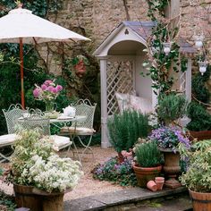 an outdoor garden with potted plants and chairs