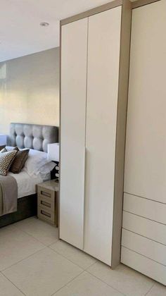 a bed sitting next to a closet in a bedroom