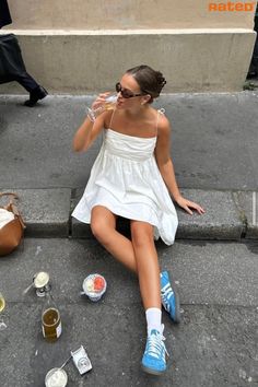 A girl in a white mini summer dress having a picnic on the pavement Looks Adidas, Pinterest Trends, Cute Vacation Outfits, Look Legging, Look Adidas, European Summer Outfits