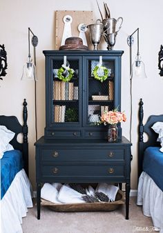 a blue dresser in a bedroom next to a bed