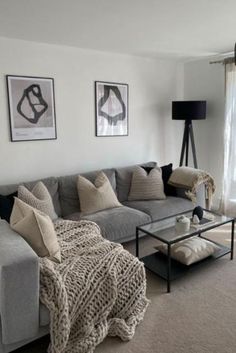 a living room filled with lots of furniture next to a window covered in sheer curtains