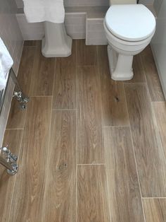 a white toilet sitting next to a sink in a bathroom