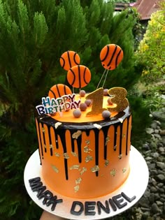 a birthday cake decorated with orange and black icing