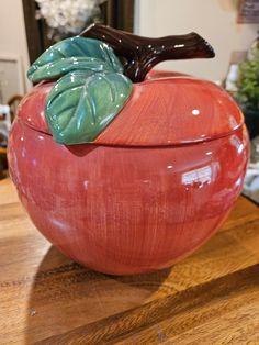 an apple with leaves on it sitting on a table