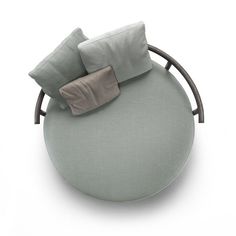 a round couch with pillows on it and a pillow in the middle that has a bow at the top