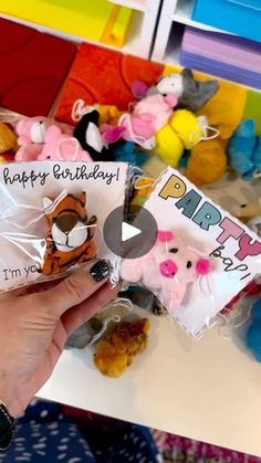 someone holding up a birthday card and some stuffed animals