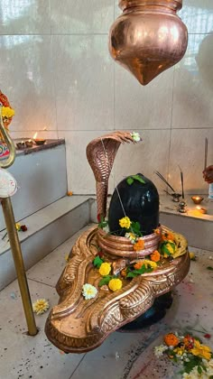 an elaborate fountain with flowers and candles on the ground in front of a wall that has been decorated