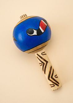 a wooden toy with a blue face on it's head and a red nose